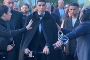 喜感拉满阿什拉夫穿戴黑披风推着助行器，蹦蹦跳跳拍照领奖